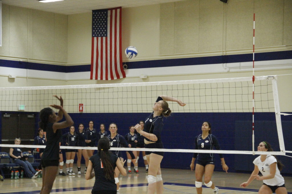 Caroline Corp about to spike the ball against the Riverside blockers.