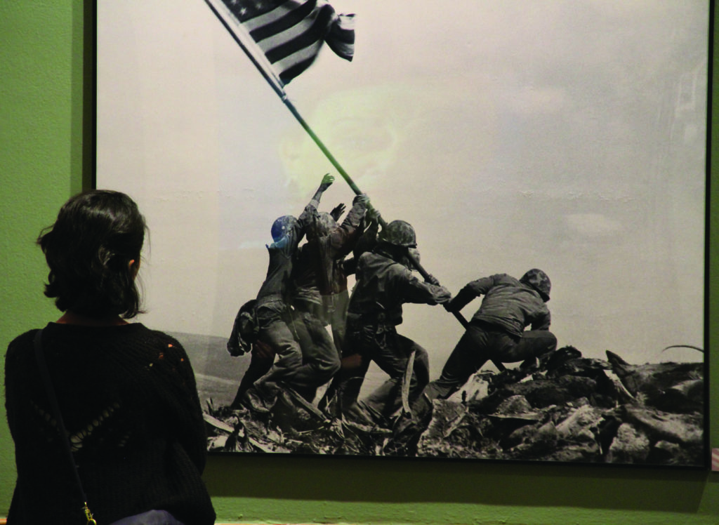 A Fullerton Art Walk attendee observes the Raising the Flag on Iwo Jima by Joe Rosenthal at the Fullerton Museums current exhibit. Photo credit: Greg Diaz
