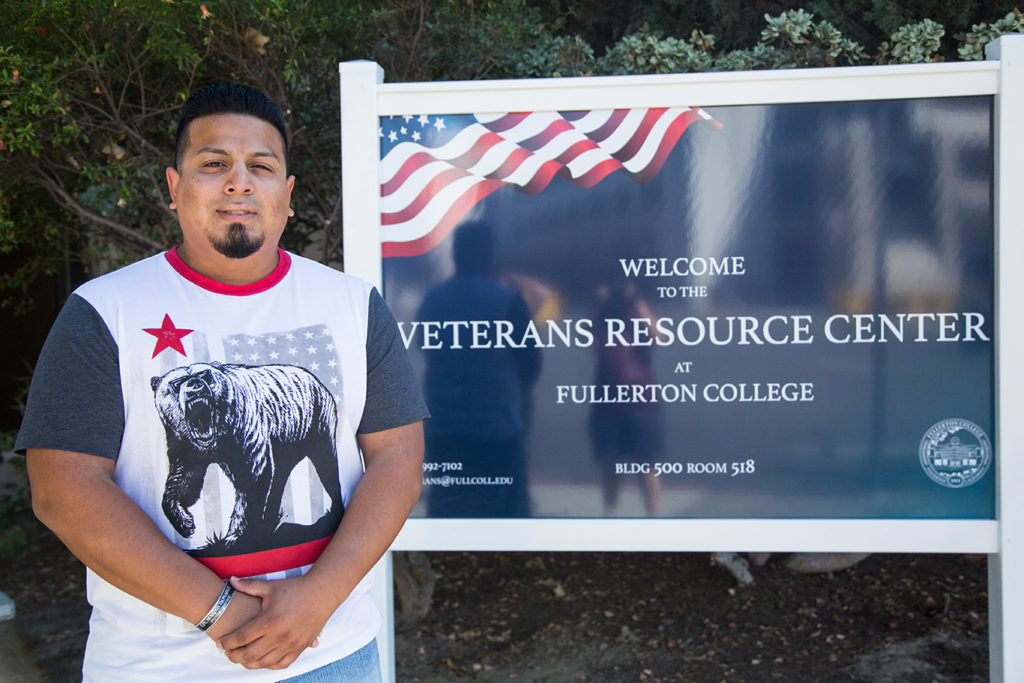 Giovanni Cruz, 27, business major and President of the Veterans Club stands next to the new sign of the Veterans Resource Center at Fullerton College. Photo credit: Sue Hwang