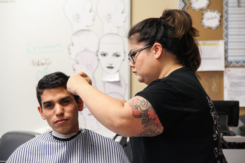 Whitney Kim, 27, cosmetology major at Fullerton College focuses on making her clients hair look good. Photo credit: Sue Hwang