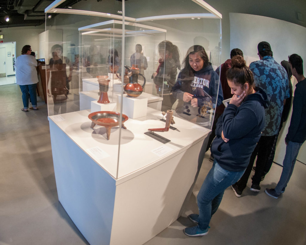 Attendees view encased items at the Fullerton College art gallery. Photo credit: Patrick Quirk