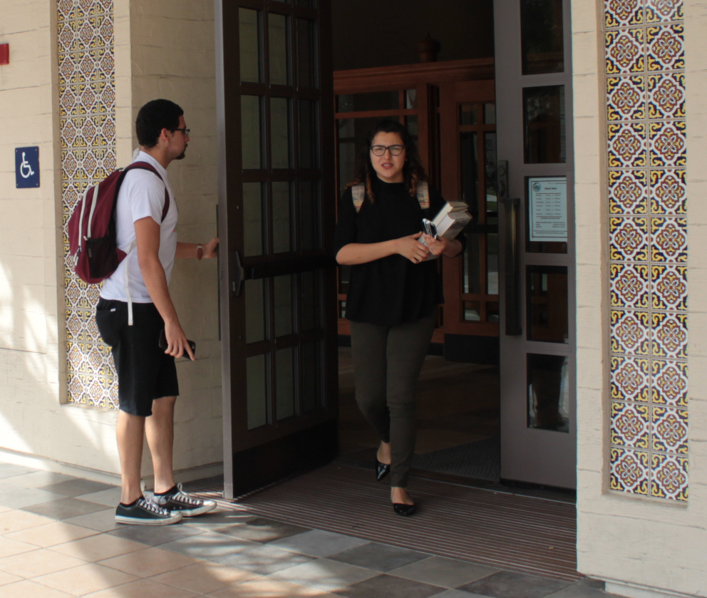 Fullerton college student holds a door open for another student to show an act of kindness Photo credit: Priscilla Aguilera