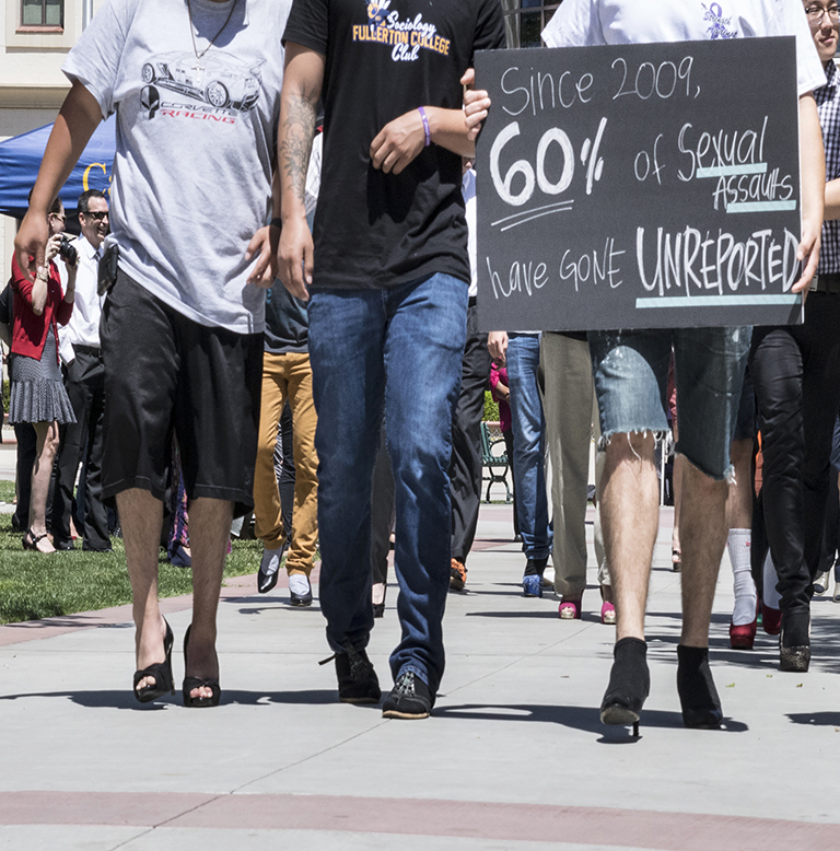 Male students leading the walk display a sign with a statistic on rape. Photo credit: Madalyn Amato