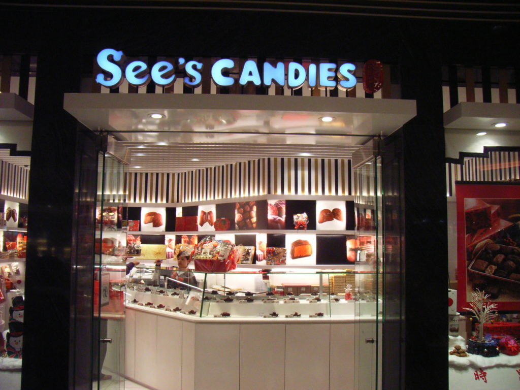 A store front for sees candies in a strip mall Photo credit: Wikipedia