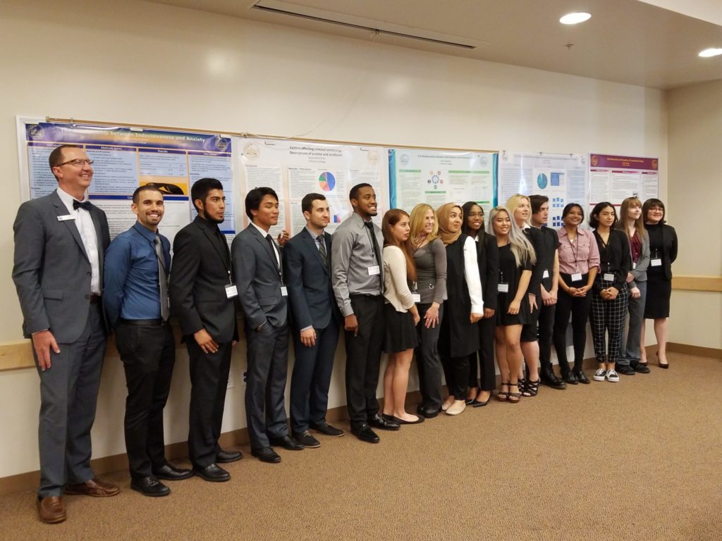 Student presenters take a group photo with psychology professor Brian Lopez and Fullerton College President Greg Schulz. Photo credit: Aaron Untiveros