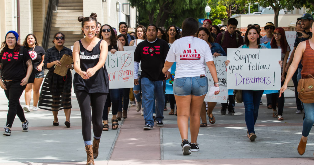 Jazmin Martinez, leads the the charge walking backwards while ralling the mass of students that marched across Fullerton College on Wednesday. Photo credit: Christian Fletcher