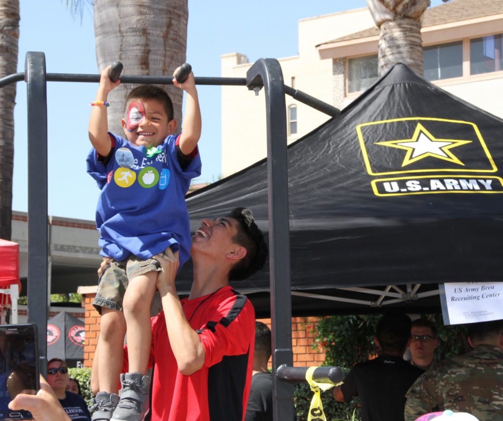 A child takes on the pull-up bar challenge at the U.S Army booth. Photo credit: Ayanna Banks