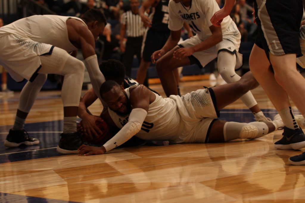 Fullerton College sophomore Jason Richardson dives on the floor to fight for possession of a loose ball during the his teams home game against Irvine Valley College on Jan. 31, 2018. Photo credit: Tameka Poland