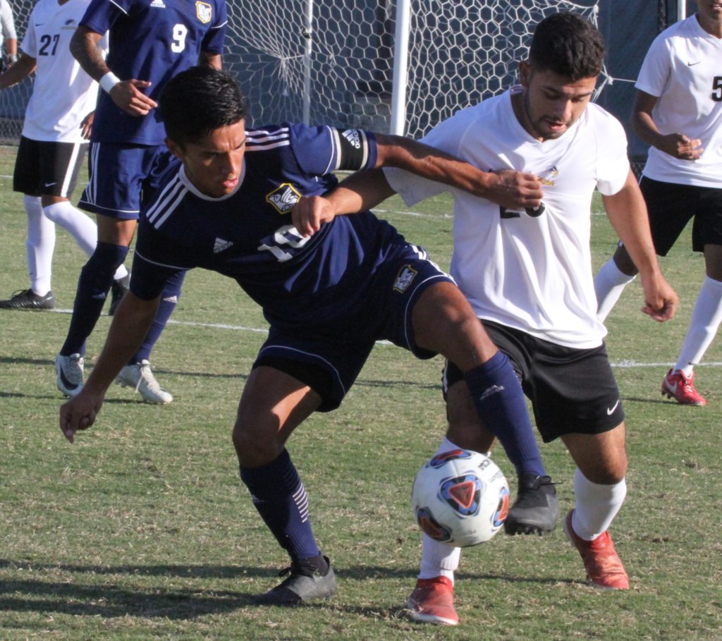 Hornets freshman forward Steve Perez fights off his defender as he tries to gain control of the ball to give his team possession and a chance at goal. Photo credit: Bovie Lavong