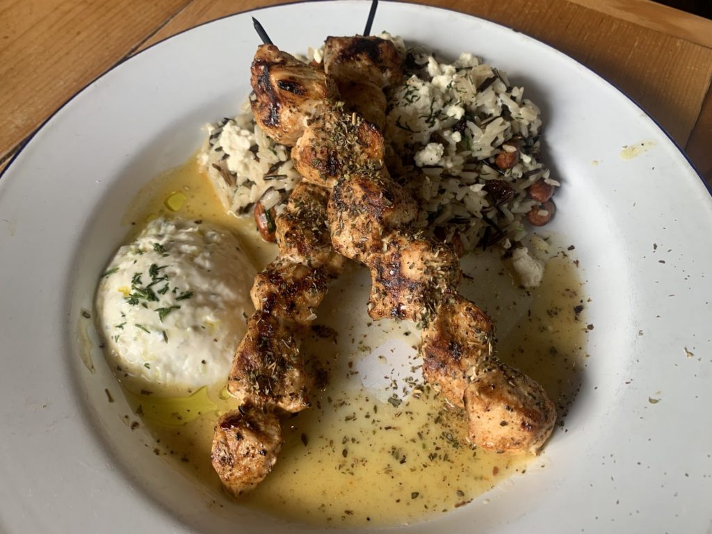 The souvlaki entrée with chicken, wild rice, and a side of tzatziki sauce. Photo credit: Janice Garcia