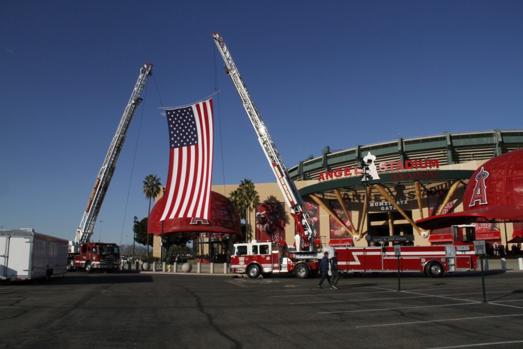 Fire engines drape the American flag outside Angel Stadium in honor of the Altobelli Family in Anaheim, Calif. Photo credit: Gabe Larson