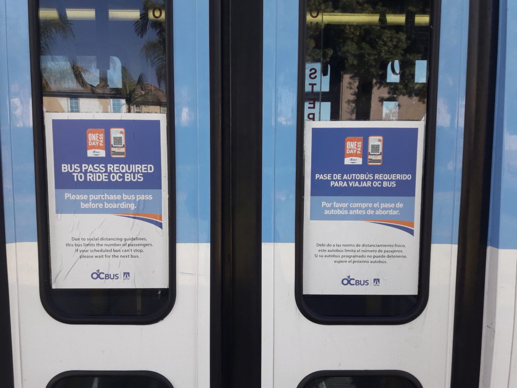 The back entrance of the bus reminds riders that a bus pass is still required to ride all OCTA buses. Photo credit: Sudabeh Sarker