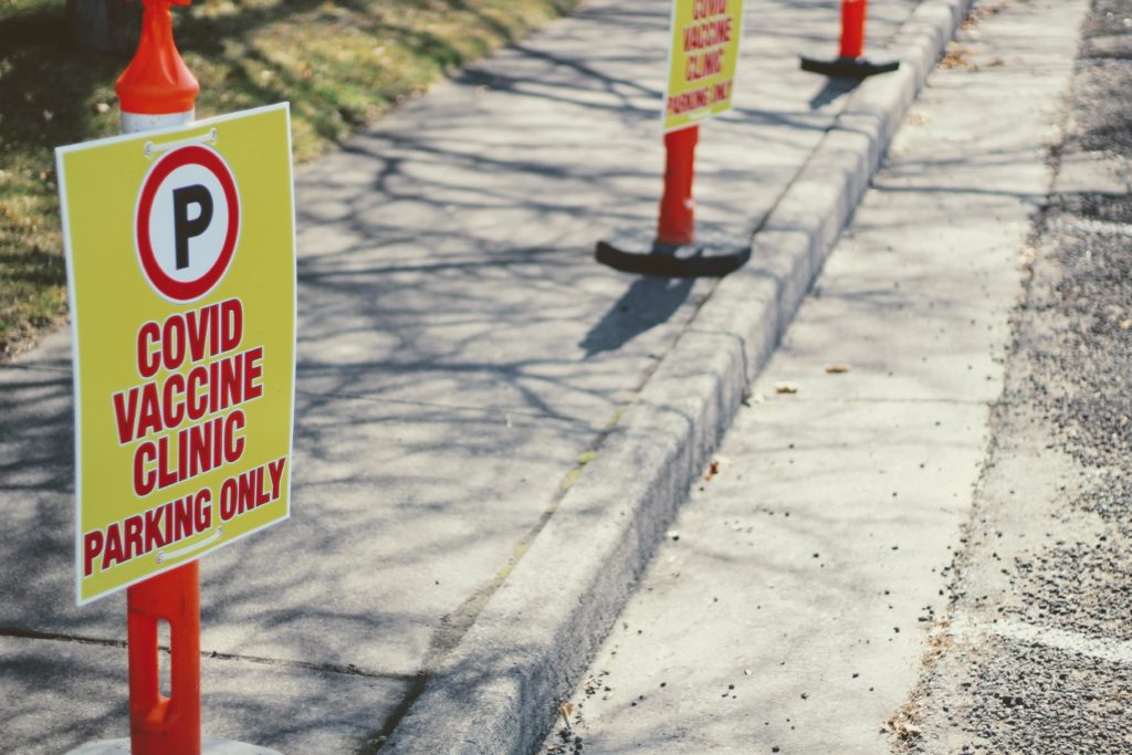Street cones with signs reserving parking for  covid vaccine clinic Photo credit: Joshua Hoehne via Unsplash