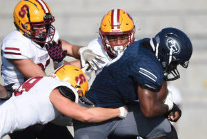 Fullerton College freshman running back Branden Rankins bulldozes his way through three defenders en route to a 148-yard and two touchdown performance. The Hornets were able to rally behind Rankins for a 31-30 win against the Bobcats. Photo credit: Matt Brown