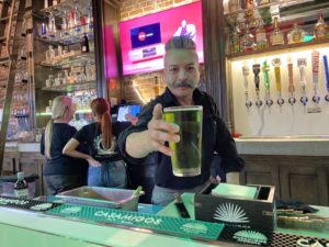 Arturo Bautista, a bartender at Garcias, delivers a green beer for St Patricks Day Celebration in downtown Fullerton. Photo credit: Dustin Malek
