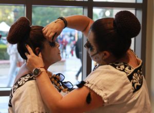 Mariza Perez and Cynthia Flores finish their face paint before they perform in the Fullerton College Quad on Nov. 2, 2022, for Dia De Los Muertos event. Photo credit: Gerardo Chagolla