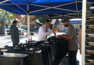 Joey Rocha and Rod Garcia stuff bags with food and drinks to hand out to people for the Thanksgiving drive-thru event on Tuesday, Nov. 22, 2022, at the Fullerton College campus. Photo credit: Jasmyn Ramirez