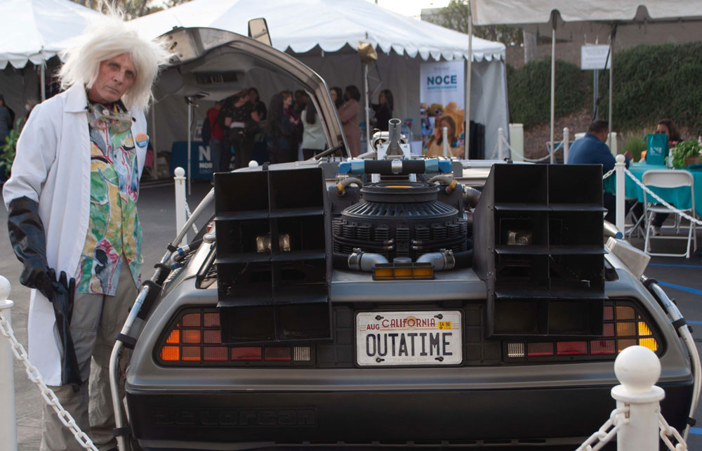 A Doc Brown impersonator poses with the DeLorean from Back to the Future at Chancellor Brelands community fair on Nov. 30, 2022. Photo credit: Dana Rose Crystal