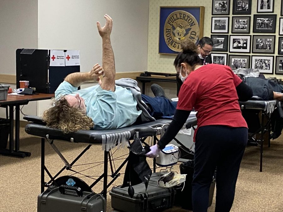 Donor, William Mittler covering the spot on his arm where their needle went in after being removed, at The Fullerton College's American Red Cross blood drive event.