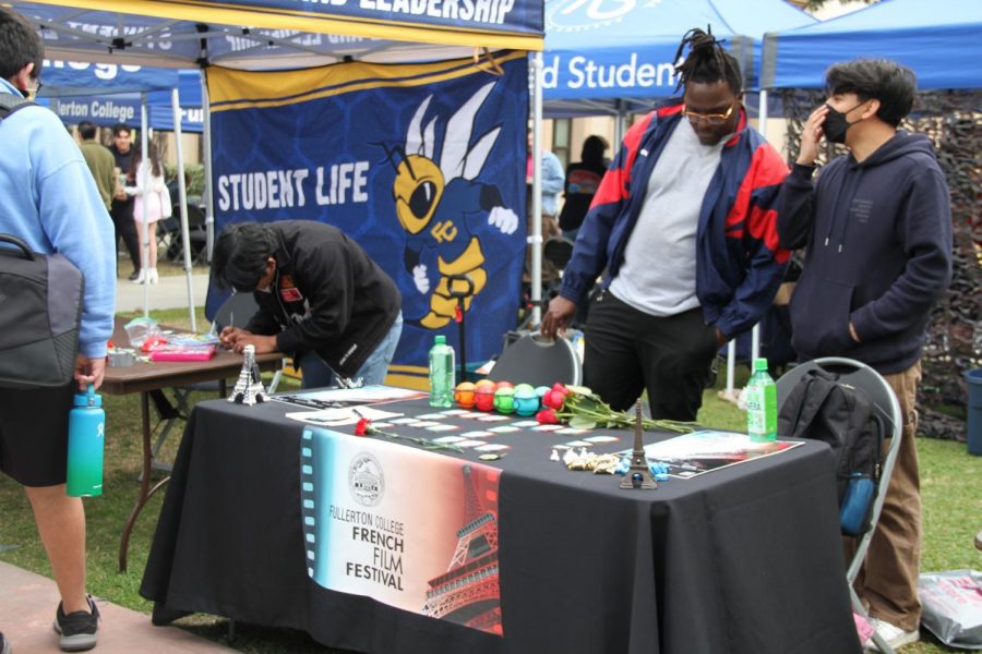 Sophmore student Richard Gerard listening to his club mate at the French Club during Fullerton College’s gold rush event on Tuesday Feb. 14, 2023