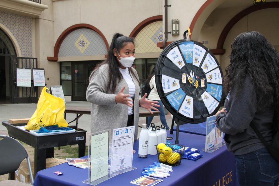 Member of the Health services at Fullerton College Ashley Mariano explaining a student about their services at the Gold Rush event on Tuesday Feb.12, 2023