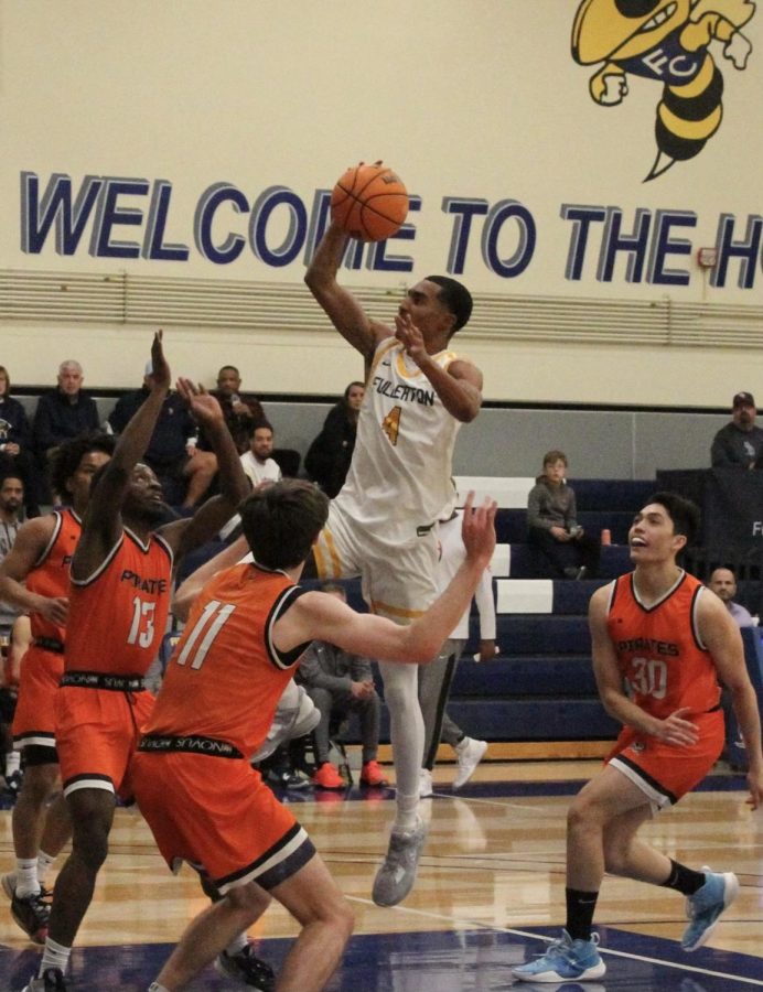 Freshman guard Sean Newman Jr. rises up to finish at the rim over four Orange Coast defenders on Friday, Feb. 3.