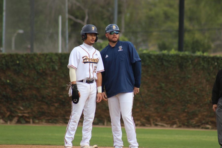 Catcher Haku Dudoit discussing the play with a staff coach from the Hornets. Feb. 2, 2023