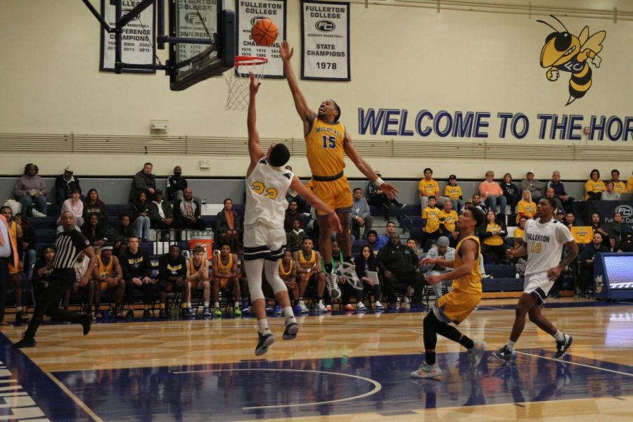 Sophomore guard Kobe Newton puts the ball high and off the glass to score over the leaping sophomore guard Devan Ford at Fullerton College on Feb. 25, 2023. Photo credit: Yasmin Sotelo