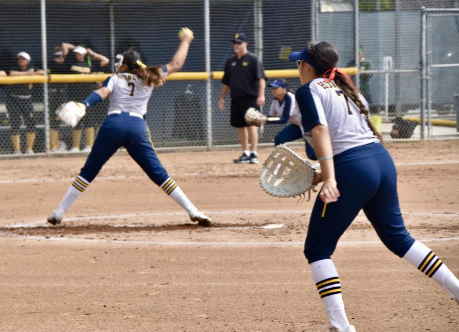First baseman, freshman Meah Almaraz, in the foreground jockeying for position as Freshman pitcher, Allyson Funtes, who went for four innings with only one hit, winds up for her pitch during Friday's game on March 17, 2023.