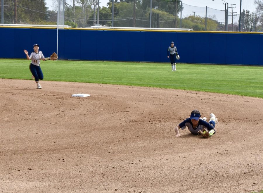 Second baseman, freshman Jordan Elias, dives for a line-drive hit to get the runner out at first on Friday, March 17, 2023 home game.