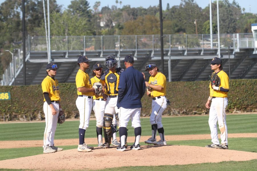 Head coach Chad Baum on a call out with sophomore pitcher Nathan McManus and other players during the 9th inning at Hornets vs Renegades game on Friday Mar. 3, 2023