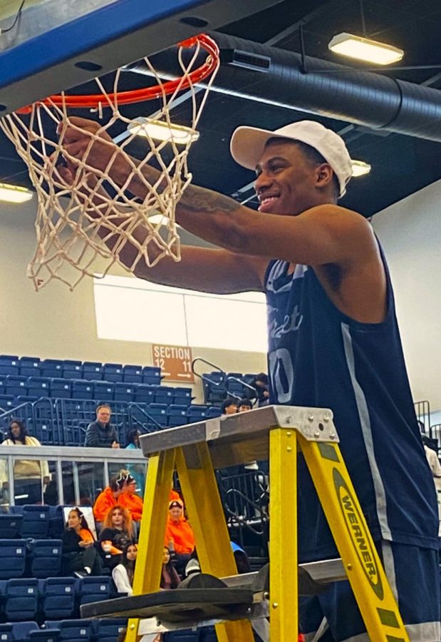 CCCAA Tournament MVP sophomore guard Shaquil Bender, usually a stoic young man, cuts down the net with a big smile following Fullerton Colleges state championship win over City College of San Francisco on Mar. 12, 2023. Photo credit: Jake Rhodes