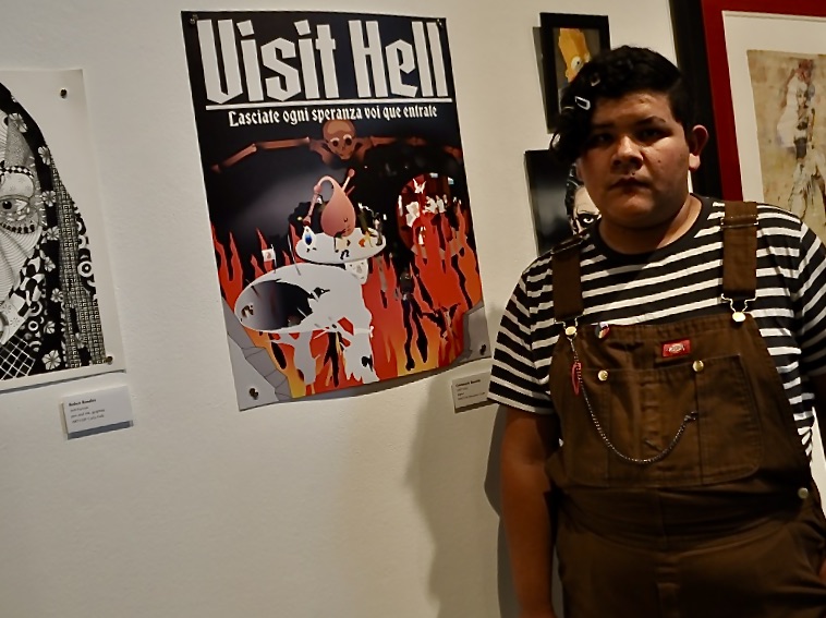 (a young male college student stands next to his artwork, of his depiction of "hell" in an art gallery) artist Getzemany Bayardo, with his artwork: "Visit Hell." At the Fullerton College Student Art Show, Thursday, April 27, 2023.