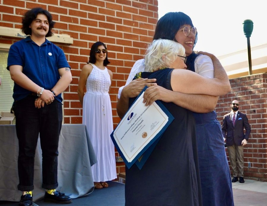 Artist Vanessa Franchi, winner of Best of Show for “Desire to Improve” (mixed media). She also won the John F Parker Scholarship, donated by Helen Parker, his widow, who hugs Vanessa Franchi. At the Fullerton College Student Art Show, Thursday, April 27, 2023.