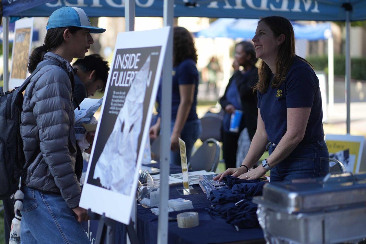 Hornet adviser Jessica Langlois talks with students at the Hornet Media info booth at the Oct. 11, 2023, centennial celebration in the Fullerton College quad.