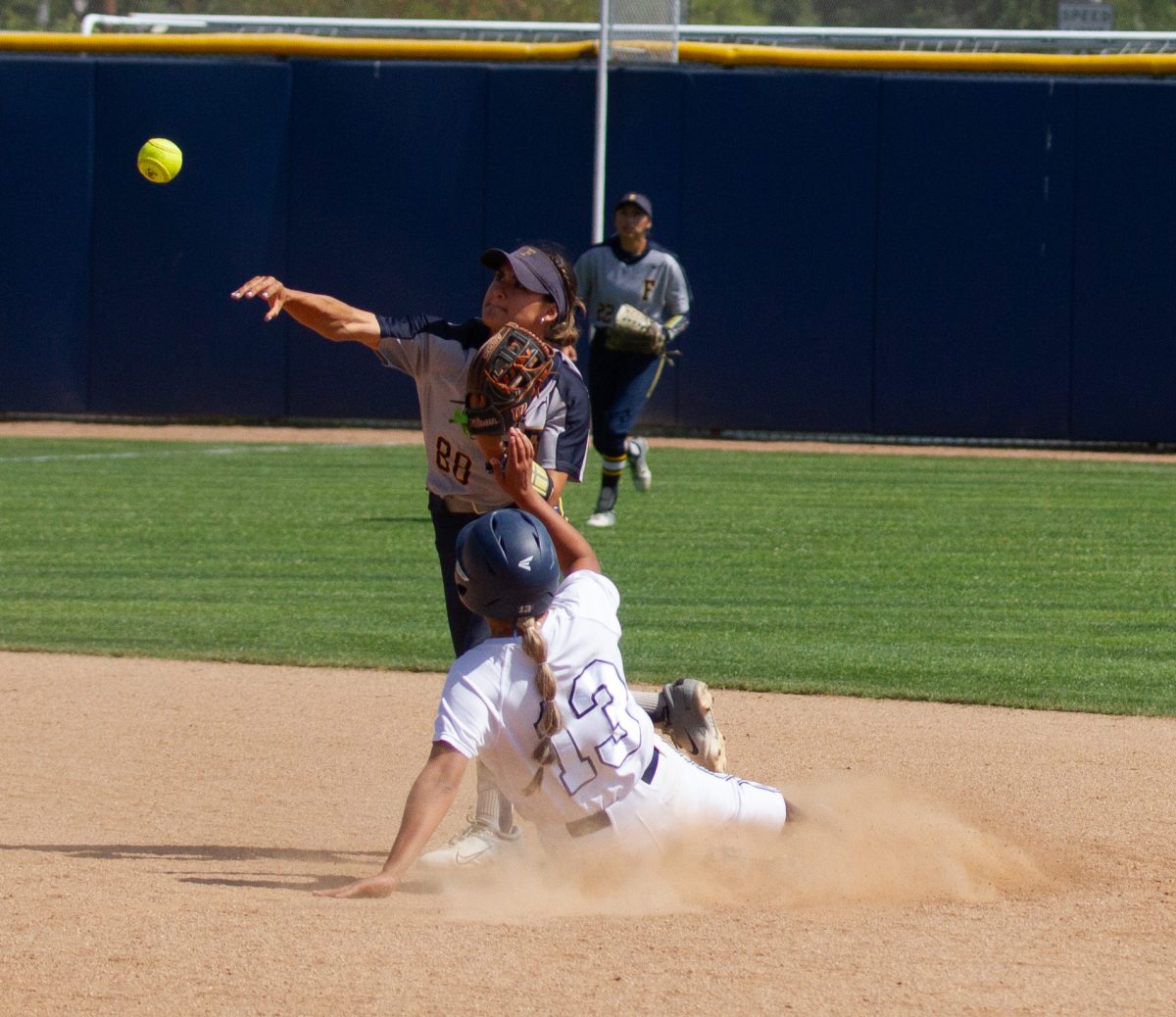 Fullerton sophomore second baseman Jordan Elias looks to turn a double play while Cerritos catcher Nadia Landeros slides into second base during Game 1 of the 3C2A Super Regionals at Fullerton College on Friday, May 10, 2024.