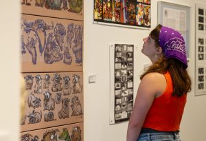 First-year art major Brenna Morse gazes at “Character Design Sketches for Animation Design,” by Phil Dimitiadis at the Fullerton College Faculty Art Gallery on Sep. 12, 2024.