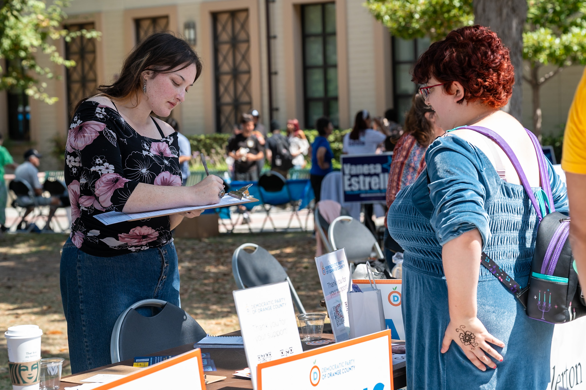 Elleana Tanner from the Democratic Party of Orange County, helps students register to vote during the Club Kickoff at the quad on Monday Sept. 16, 2024.