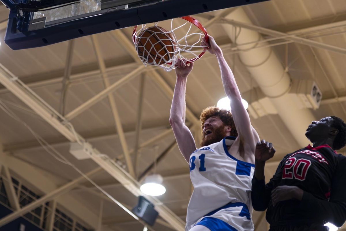 Joe Grahovac dunks the ball into the basket as Mourad Toure looks at the dunk in the regional final game in the Hornet's Nest in Fullerton Calif.