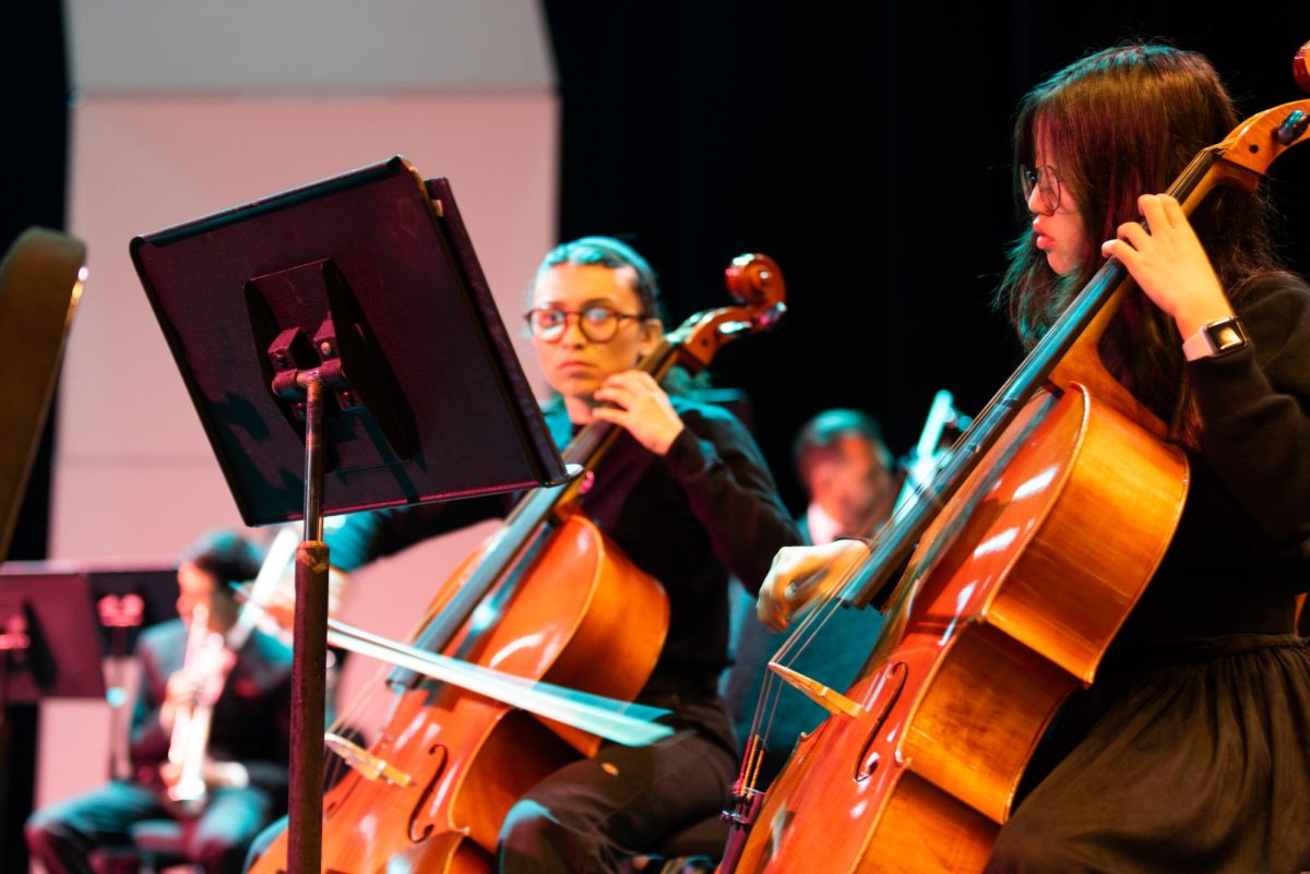 Tabitha Martinez (left) and Rachel Seo rehearse with their violoncellos before their performance in the Fullerton College Symphony at the Campus Theatre on Wednesday, April 23.