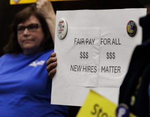Member of the CSEA holds a sign to show one of the reasons they are rallying for on April 22, 2025 in Anaheim Calif.