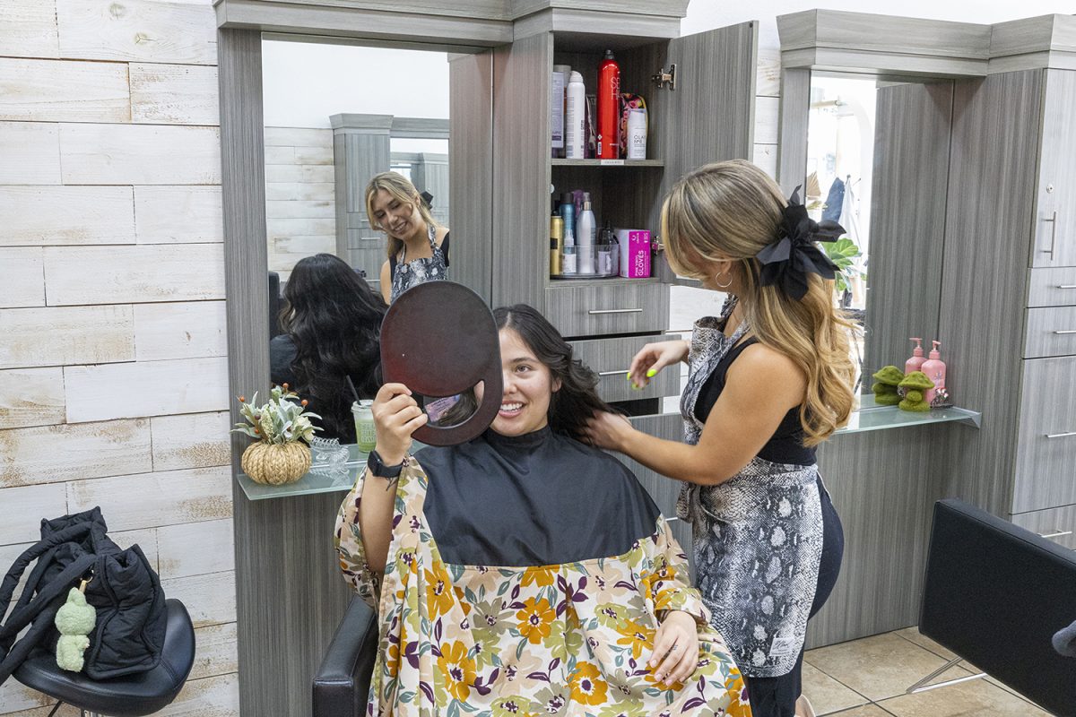 Cristal Martinez’s client smiles as she sees the result of her haircut at Salon Amerige in Fullerton, Calif.
