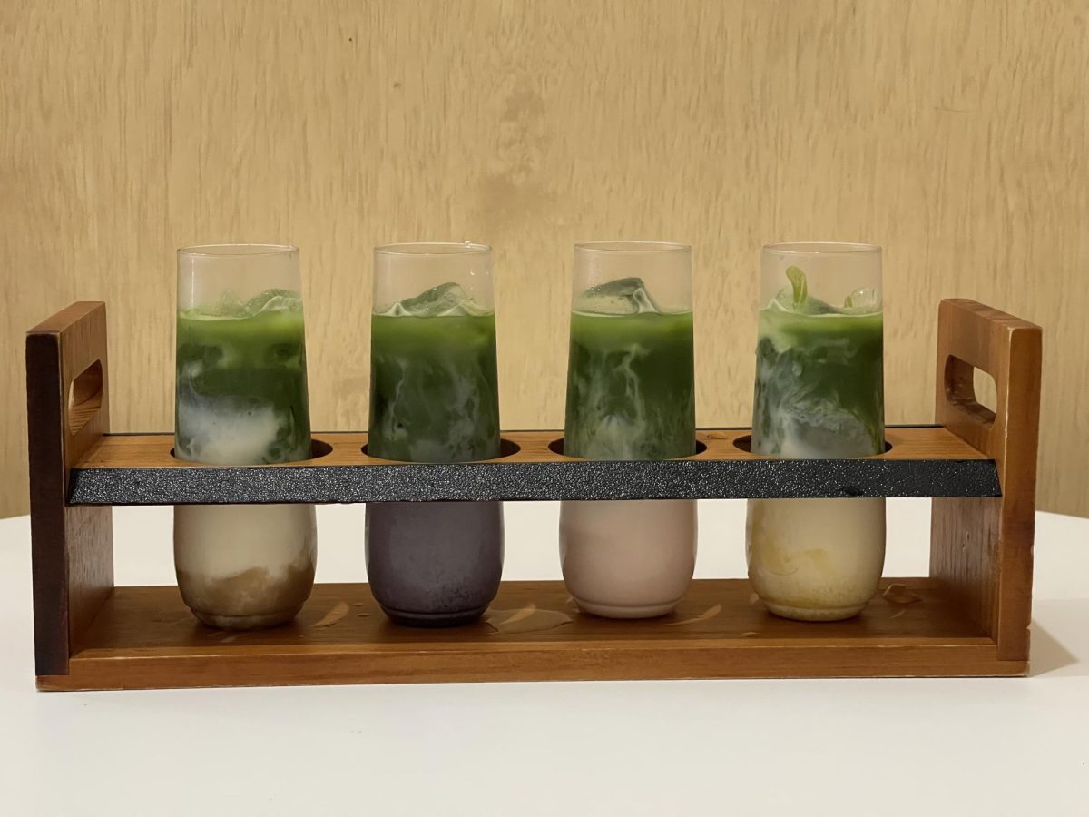 A Fruit Matcha Flight featuring banana, blueberry, guava, and mango flavors is served at Vivot Craft Cafe in Downtown Fullerton, Calif. The four-drink set is presented in a wooden tray.