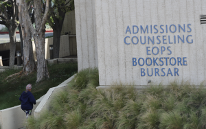 A student walks toward the 2000 building, which houses the admissions and counseling offices. 