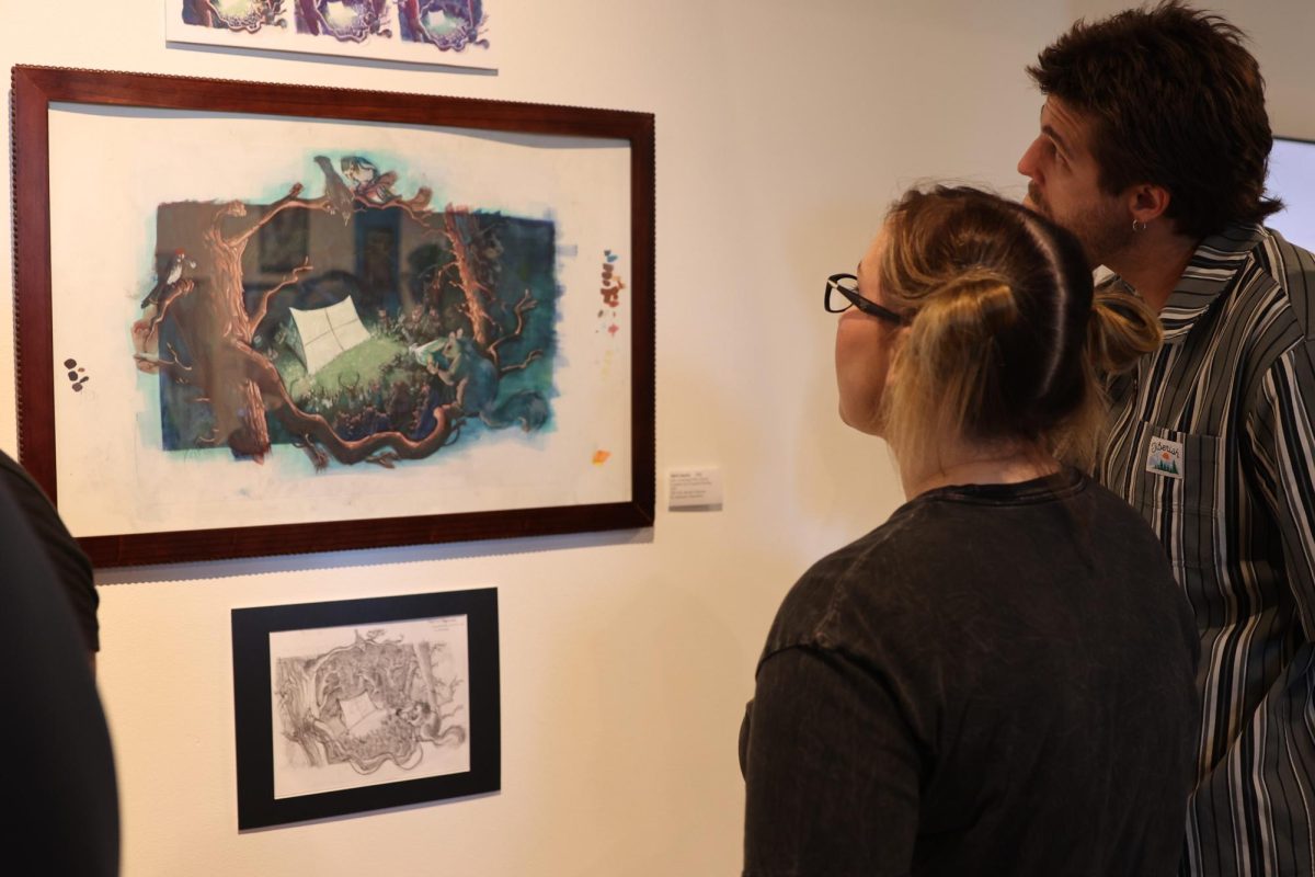Brandy By (left) and Ryan Byl observe Mark Huerta’s Lake Arrowhead Film Festival graphite and gouache painting at the Student Art exhibit on May 8, 2025.