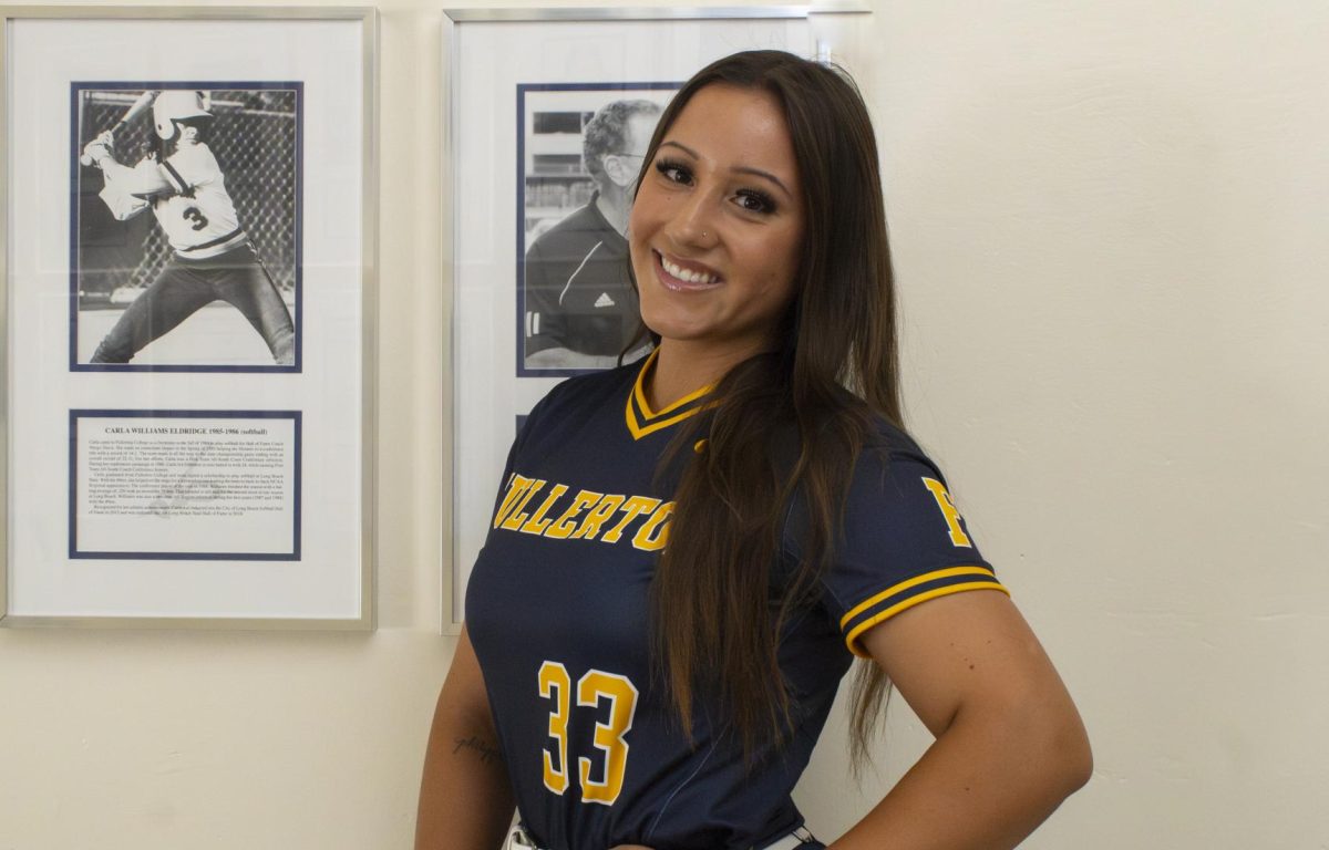 Fullerton College Hornet's Veronica Moore poses next to a photo of softball player Carla Williams Eldridge in the Gym at Fullerton College on May 18, 2025.
