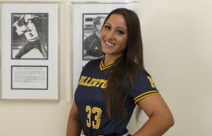 Fullerton College Hornets Veronica Moore poses next to a photo of softball player Carla Williams Eldridge in the Gym at Fullerton College on May 18, 2025.
