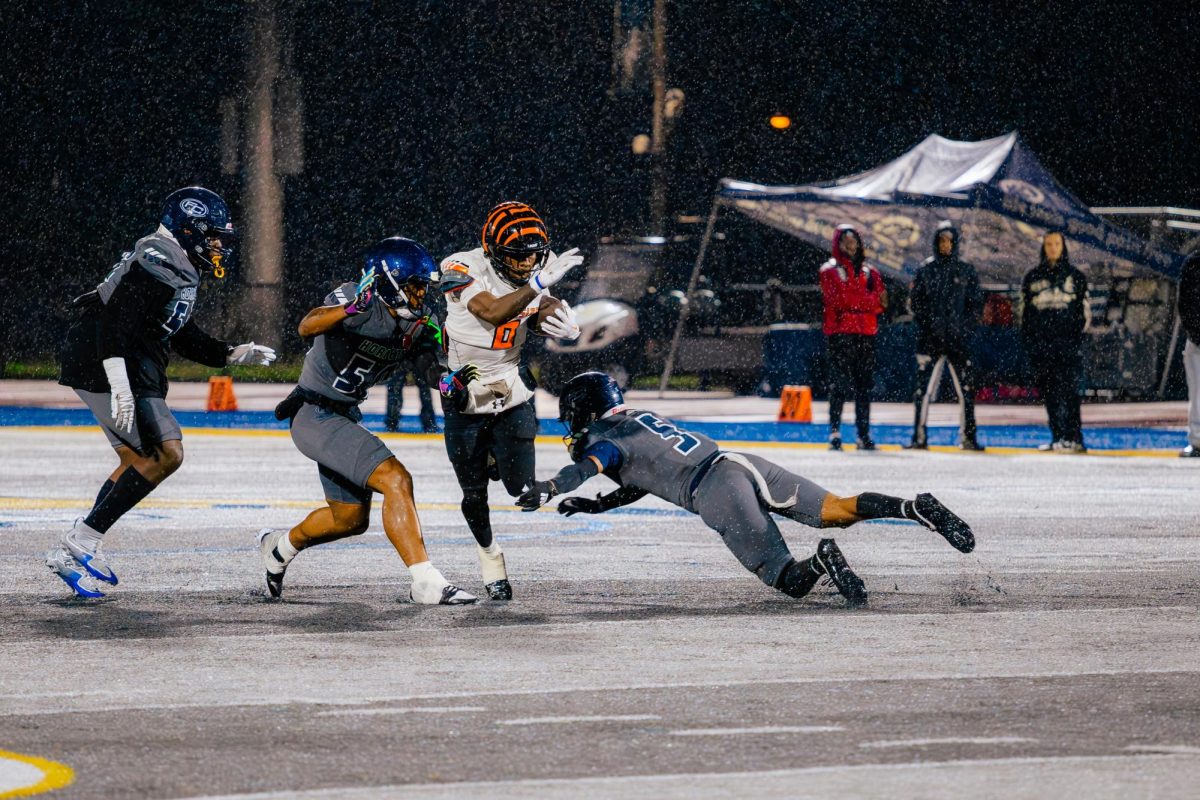 Fullerton defensive back Xander Chisolm, attempts to make a tackle against Riverside running back Kayvion Sibley, as rain is pouring down.