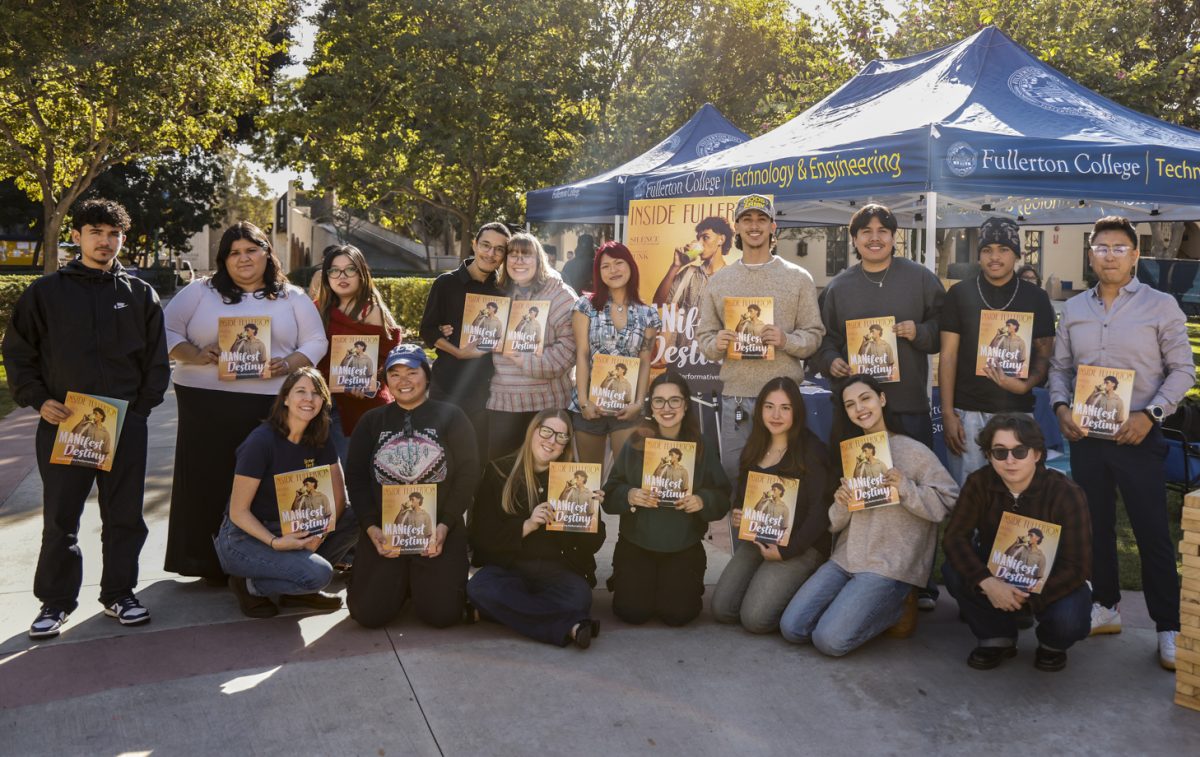 Editors and staff of Inside Fullerton pose with the new issue of the magazine and a poster of the cover at the launch party on Wednesday.