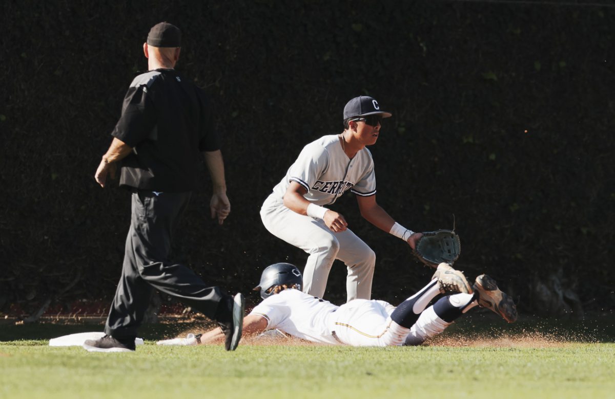 Fullerton catcher Nate Pone slides in hands first into third base against Cerritos.